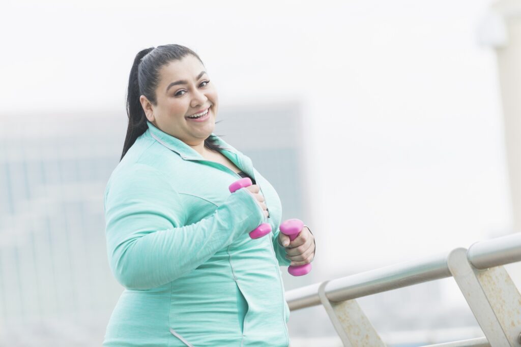 overweight hispanic woman running or jogging outdoors